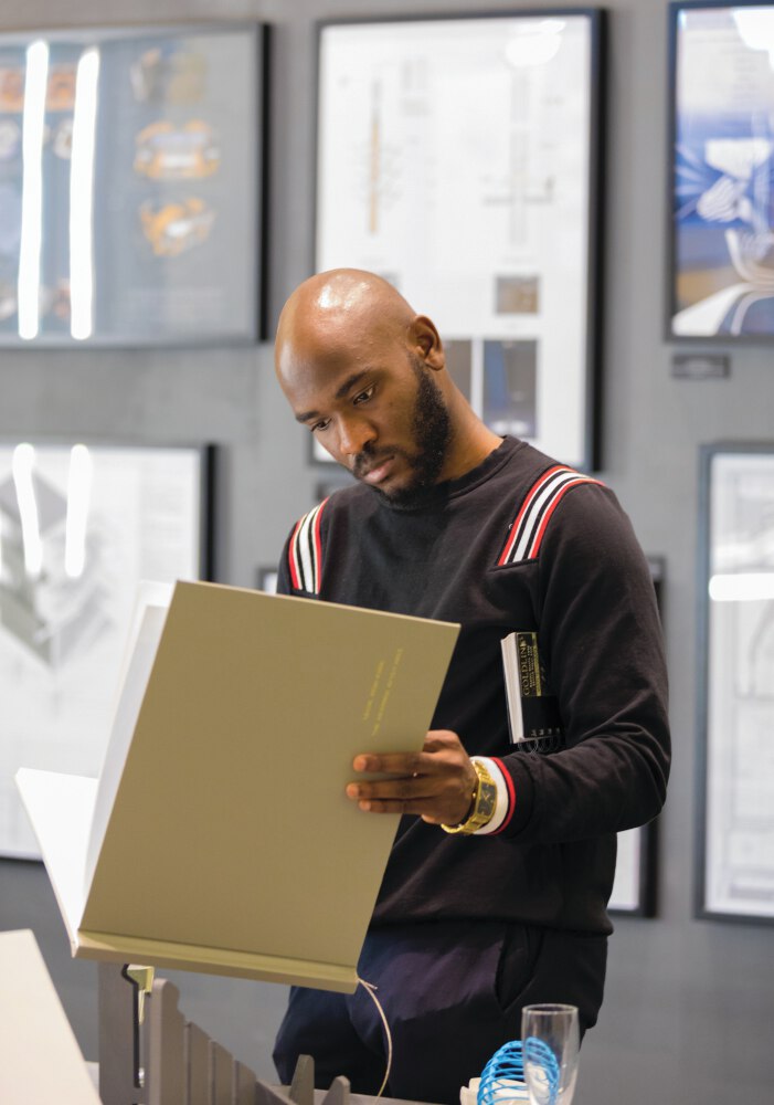 Person looking at a sample of work, a portfolio, at one of the uiveristy's design shows