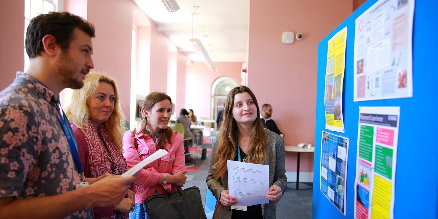 An image of staff and students reviewing presentations at the Placement Recall Day.