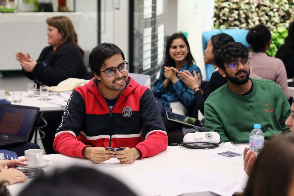 students sat at desk smiling