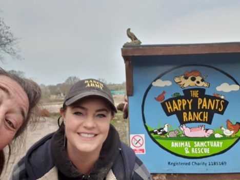 Melanie Thorley and Amey James in front of The Happy Pants Ranch sign