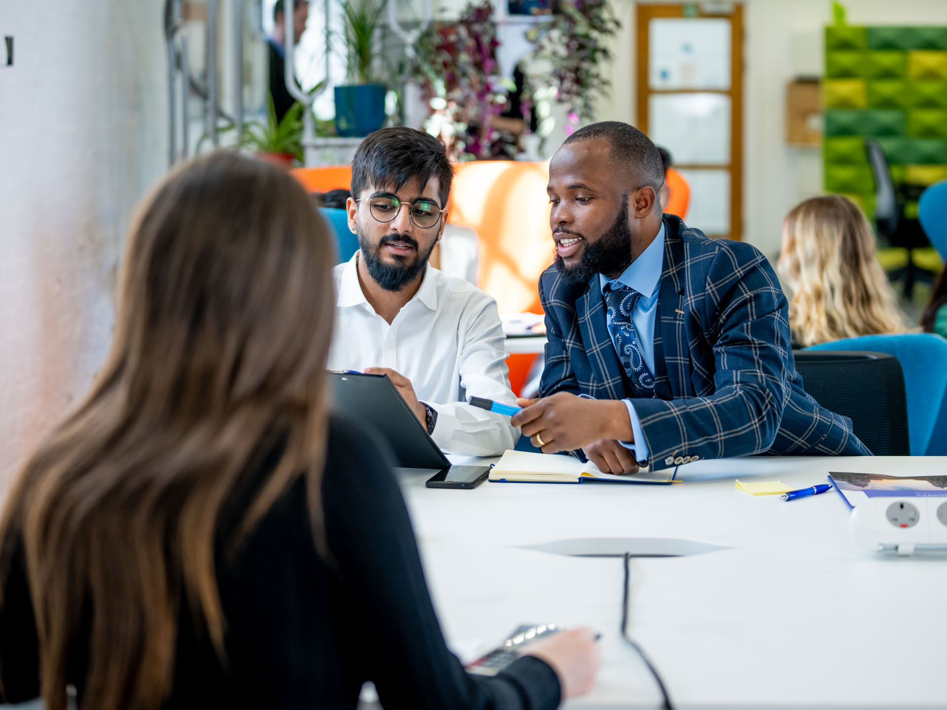 Three students working and chatting