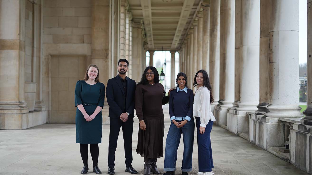 Five alumni standing on Greenwich campus