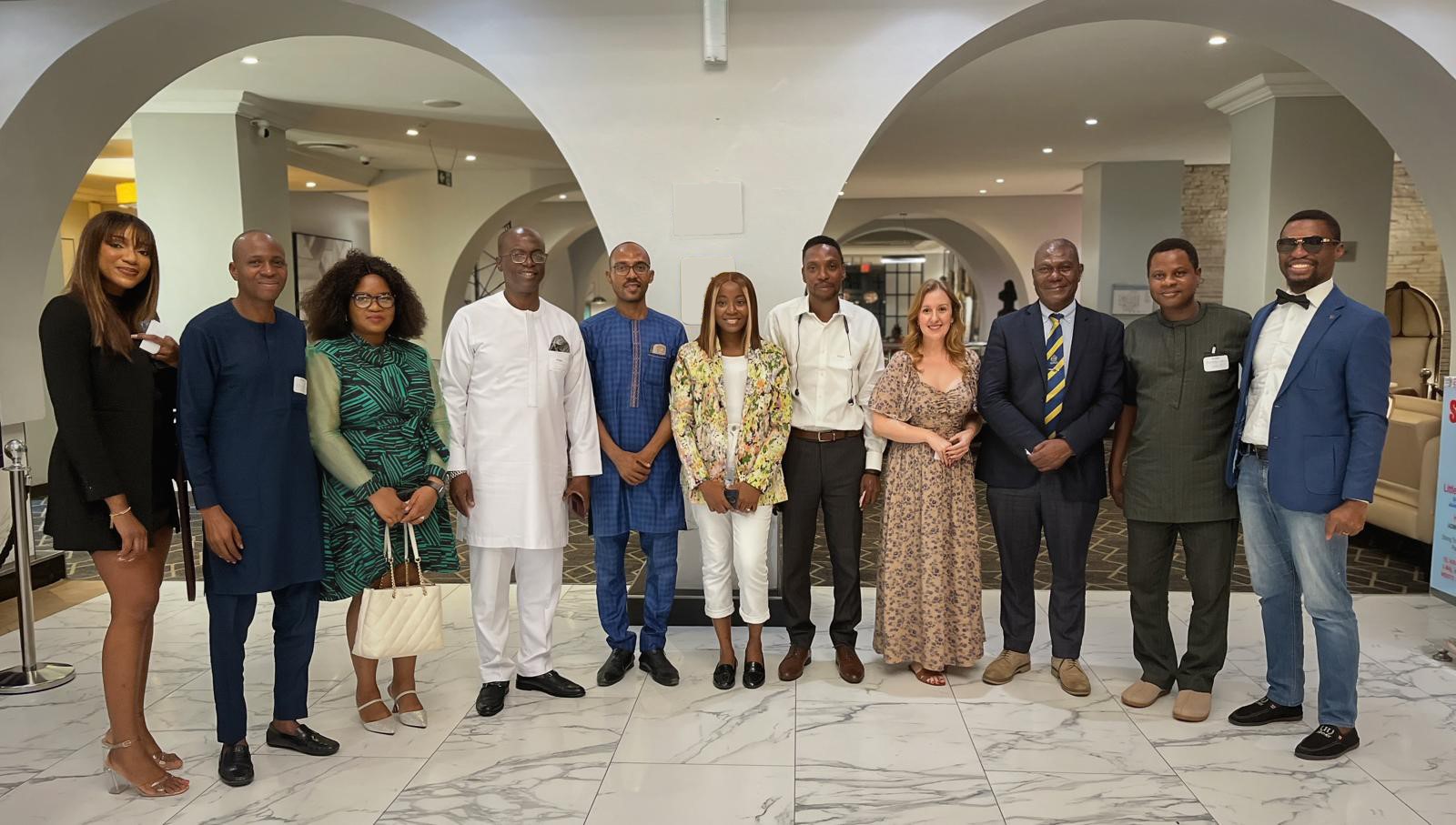  A group of alumni pose for a photo in a semicircle