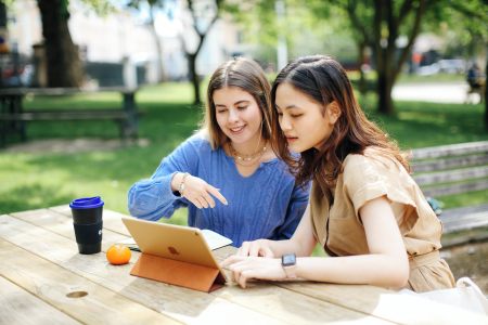 Two students working outside on a tablet